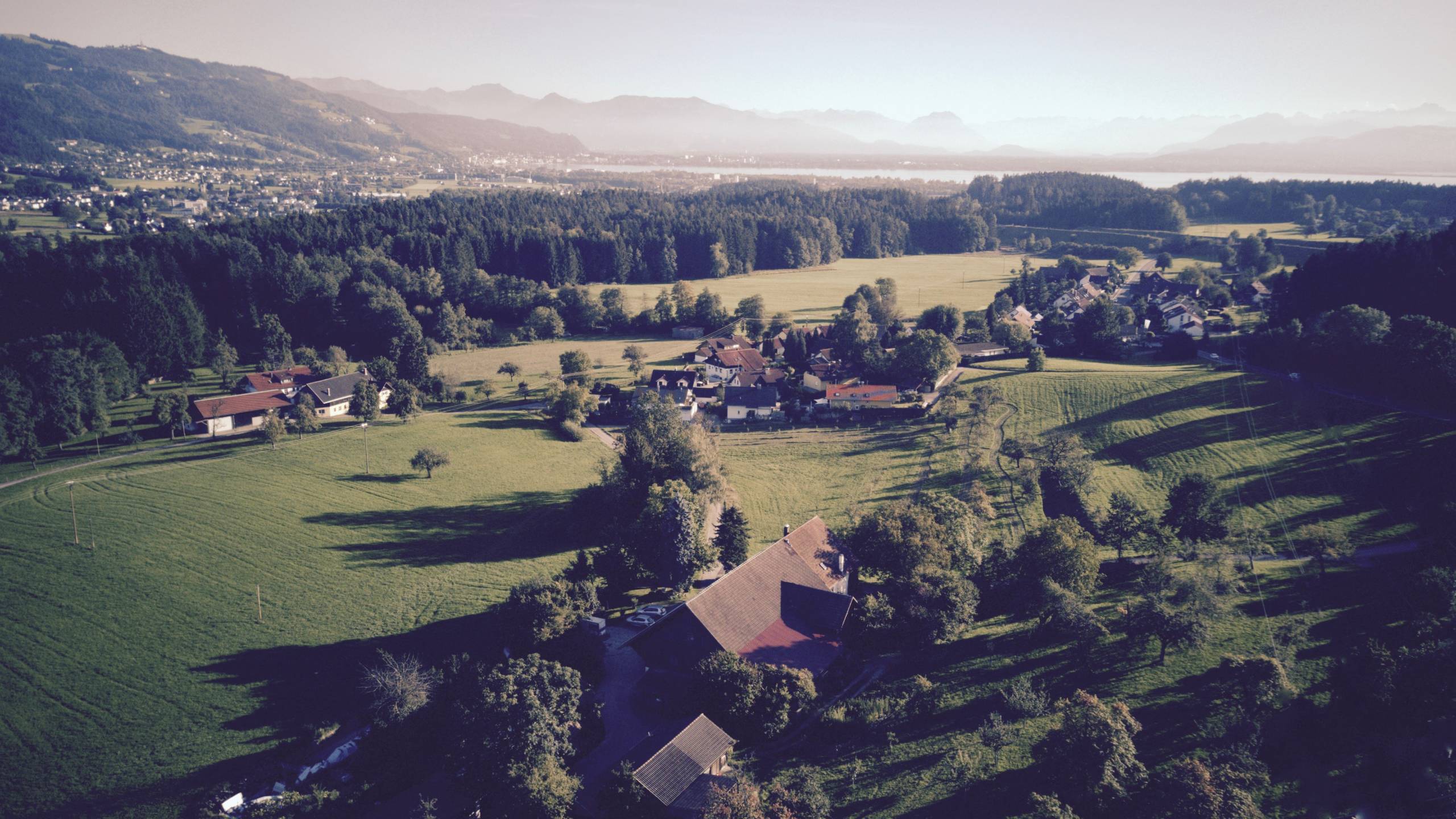 Drohnenaufnahme über dem Hof mit Aussicht Berge-Bodensee